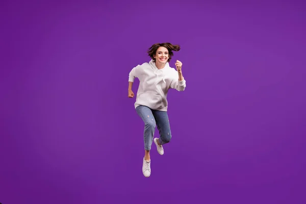 Full storlek foto av unga glada leende hona kör snabb hastighet i luften reser isolerad på violett färg bakgrund — Stockfoto