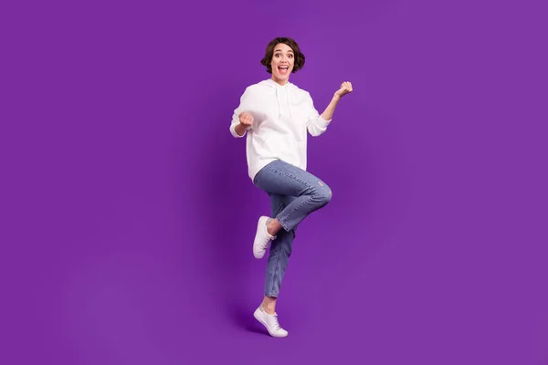 Full size photo of young excited good mood girl raise fsts in victory triumph isolated on violet color background — стоковое фото