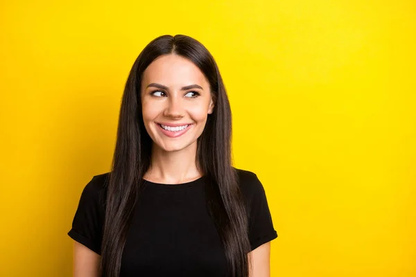 Photo portrait of pretty woman smiling cheerful wearing black t-shirt looking empty space isolated vivid yellow color background — Stock Photo, Image