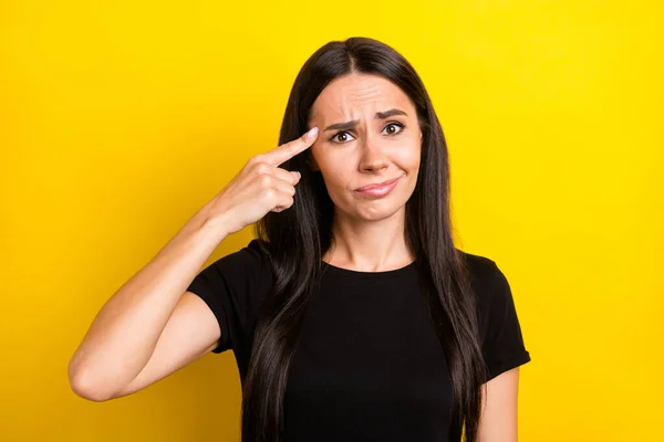 Foto von frustriert funky Dame Stirnrunzeln Finger berühren Tempel tragen schwarzes T-Shirt isoliert gelbe Farbe Hintergrund — Stockfoto