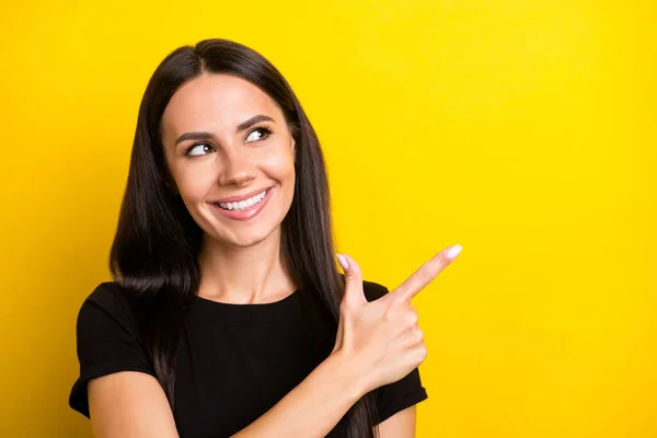 Foto de señora astuta indican dedo vacío espacio buscar desgaste negro camiseta aislado color amarillo fondo — Foto de Stock