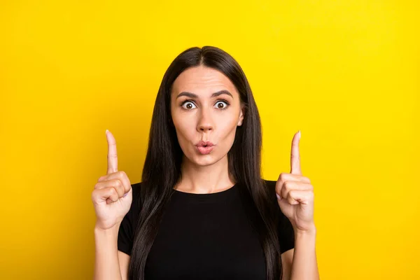 Photo of shocked crazy lady otwarte usta bezpośrednie palce puste miejsce nosić czarny t-shirt odizolowany żółty kolor tło — Zdjęcie stockowe