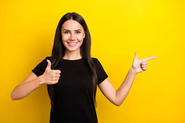 Foto de morena dama dedo directo espacio vacío levantar el pulgar hacia arriba desgaste negro camiseta aislado color amarillo fondo — Foto de Stock