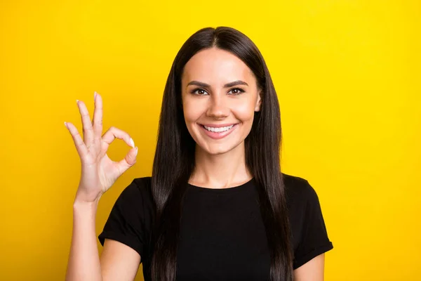 Foto di bella ragazza bruna sorriso dentato sguardo fotocamera dita mostrano okey simbolo isolato su sfondo di colore giallo — Foto Stock