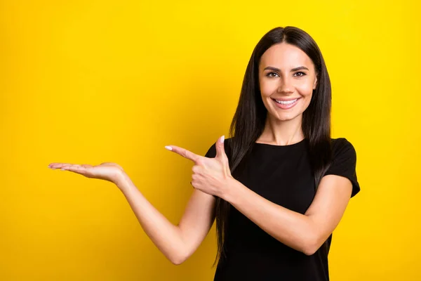 Foto de menina muito alegre braço do dedo direto palma apresentando oferta de espaço vazio isolado no fundo de cor amarela — Fotografia de Stock