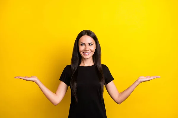 Retrato de encantador alegre menina olhar mãos palmas segurar mostrar vazio espaço proposição isolado no fundo de cor amarela — Fotografia de Stock