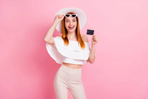 Çekici genç bir kadının fotoğrafı kredi kartı tutuyor gülümsüyor müşteri müşterisi pembe arka planda izole edilmiş hayretler içinde. — Stok fotoğraf