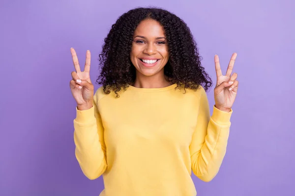 Fénykép imádnivaló fényes sötét bőr hölgy viselni sárga pulóver mutató két v-jelek mosolygó elszigetelt lila színű háttér — Stock Fotó