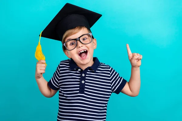 Фото сладкого мальчика точка вверх носить полосатые футболки очки шляпу, изолированные на бирюзовом фоне цвета — стоковое фото