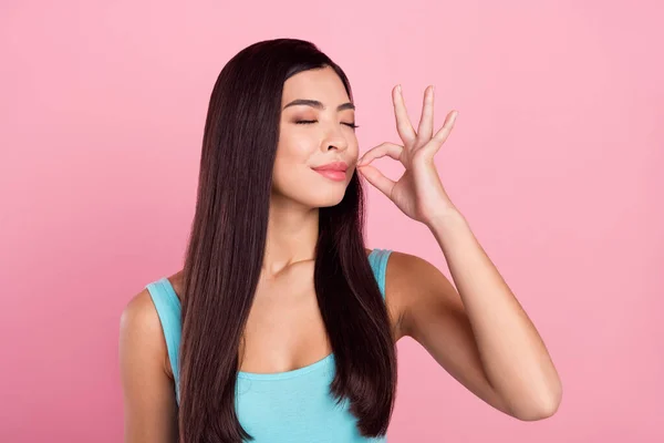 Foto wanita berambut panjang yang lucu mencoba makanan memakai atasan biru terisolasi pada latar belakang warna merah muda pastel — Stok Foto