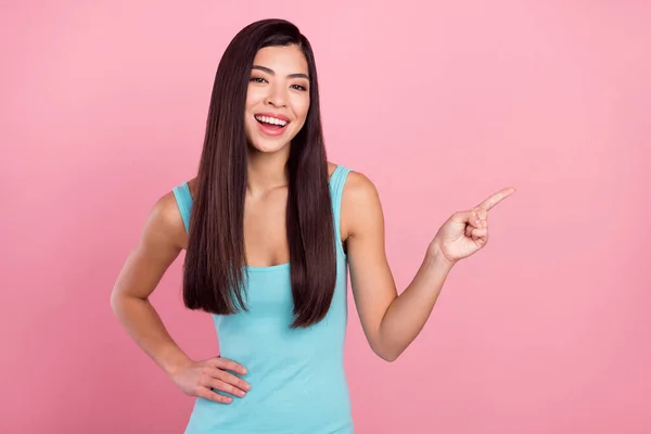 Foto retrato mujer riendo apuntando espacio vacío con el dedo recomendando aislado pastel color rosa fondo —  Fotos de Stock