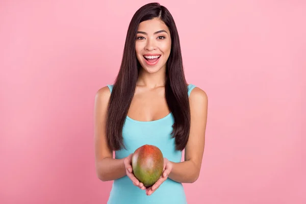 Foto retrato mulher sorrindo mantendo frutas exóticas mantendo dieta saudável isolado pastel cor-de-rosa fundo — Fotografia de Stock