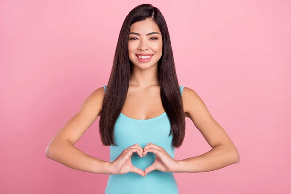 Foto di flirty millennial marrone acconciatura signora spettacolo cuore usura blu top isolato su sfondo di colore rosa pastello — Foto Stock