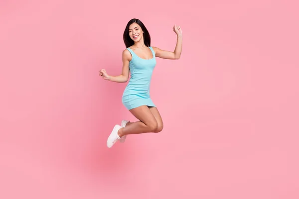 Full length profile photo of hooray young lady jump wear blue dress sneakers isolated on pink color background — Stock Photo, Image