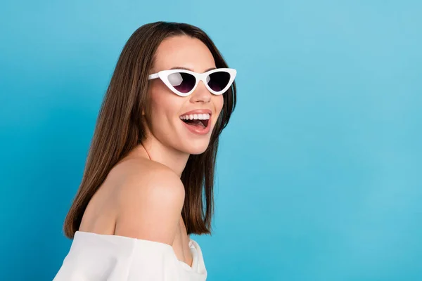 Foto de alegre jovem feliz mulher positiva olhar espaço vazio usar vidro solar isolado no fundo de cor azul — Fotografia de Stock