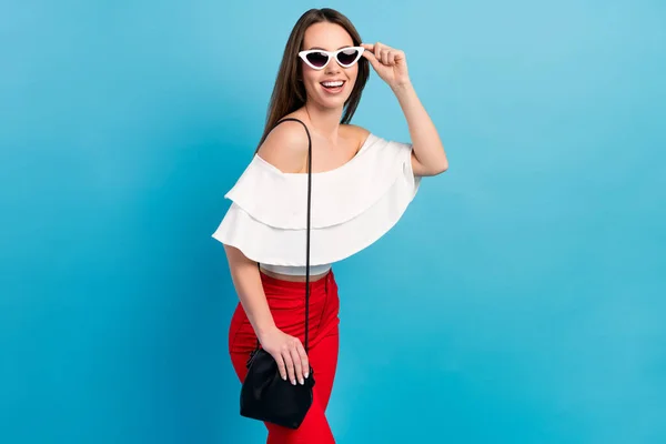 Foto de alegre jovem bonito mulher bonita feliz usar bolsa de vidro solar isolado no fundo de cor azul — Fotografia de Stock