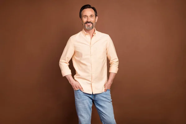 Φωτογραφία του παλαιού brunet άνθρωπος φορούν ροδακινί πουκάμισο τζιν απομονωμένο σε καφέ χρώμα φόντο — Φωτογραφία Αρχείου