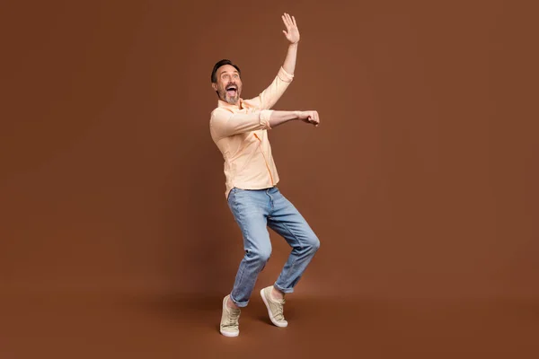 Foto de baile loco tipo funky imaginar paseo caballo usar camisa beige jeans zapatos aislados de color marrón fondo —  Fotos de Stock