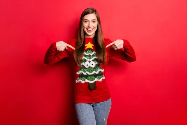 Photo of young positive woman point finger sweater funny christmas holiday isolated on red color background — Stock Photo, Image