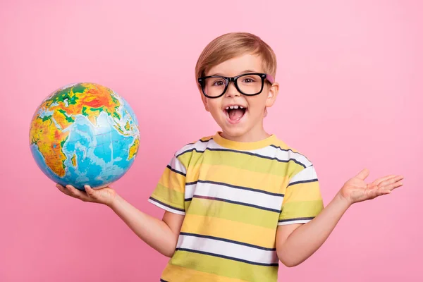 Foto de jovem menino feliz segurar as mãos globo lição óculos desfrutar fresco isolado na cor rosa fundo — Fotografia de Stock