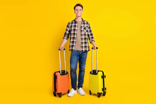 Foto do cara segurar dois sacos radiante sorriso desgaste xadrez camisa jeans calçado isolado cor amarela fundo — Fotografia de Stock