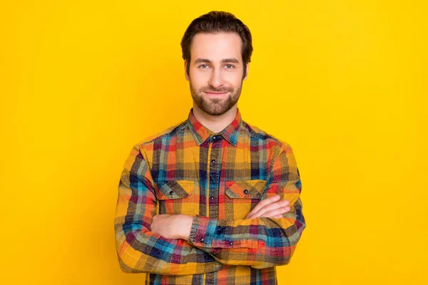 Zdjęcie uroczy pewny siebie młody facet ubrany w kratkę ramiona koszuli skrzyżowane uśmiechnięty odizolowany żółty kolor tła — Zdjęcie stockowe