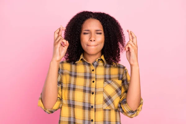Fotografie nadějná dáma zavřít oči zkřížené prsty kousnutí ret opotřebení kostkované košile izolované růžové barvy pozadí — Stock fotografie