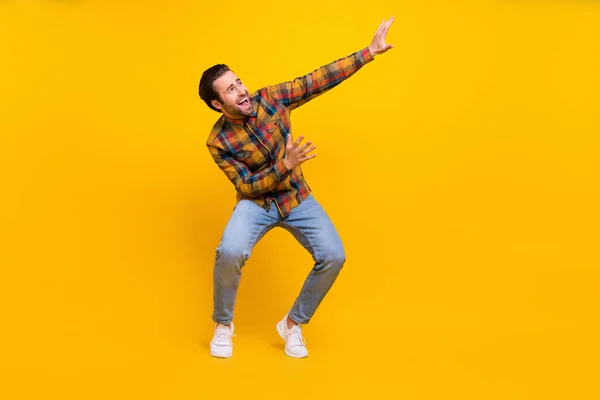Pleine taille photo de fou brunet jeune gars danse porter chemise jeans baskets isolé sur fond jaune — Photo