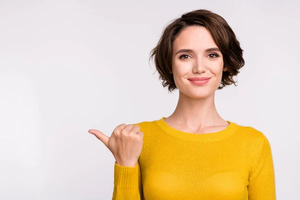 Foto de otimista morena millennial senhora ponto espaço vazio desgaste camisa amarela isolada no fundo de cor cinza — Fotografia de Stock