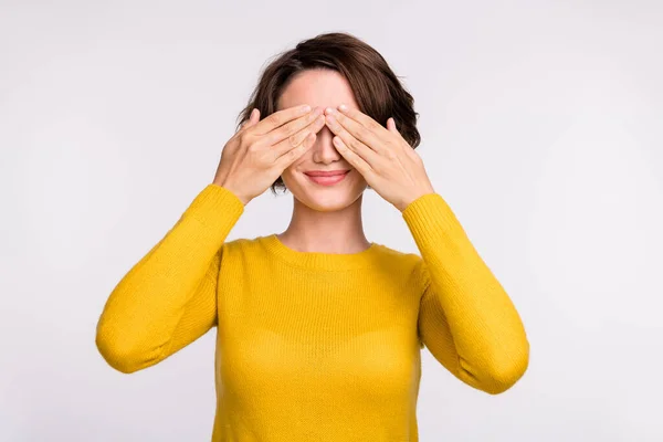 Foto von fröhlichen interessierten Mädchen Hände bedecken Augen friedliches Lächeln tragen gelbes Hemd isoliert graue Farbe Hintergrund — Stockfoto