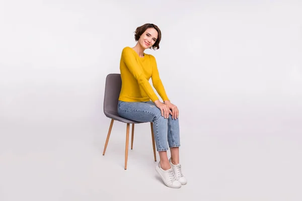 Teljes méretű profil oldalán fotó fiatal lány boldog pozitív mosoly ül széklet viselése alkalmi ruhát elszigetelt szürke színű háttér — Stock Fotó