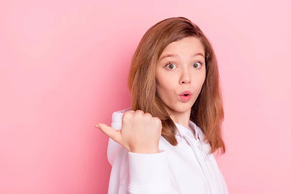 Портрет привлекательной модной изумленной девушки, демонстрирующей рекламу копировального пространства на розовом пастельном фоне — стоковое фото