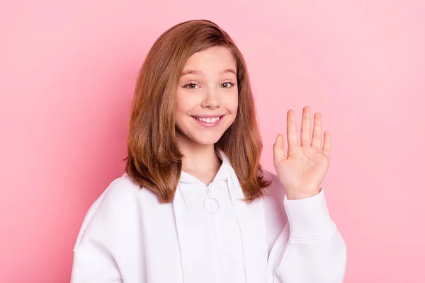Zdjęcie portret dziewczyna macha ręką na spotkanie uśmiechnięty pojedynczy pastel różowy kolor tła — Zdjęcie stockowe