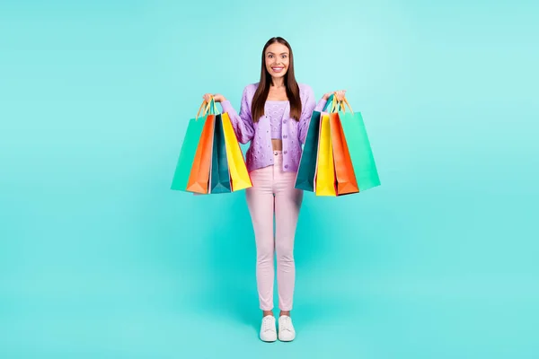 快乐的顾客女士拿着零售包装的照片，穿着紫色羊毛衫，背景是深蓝色的 — 图库照片