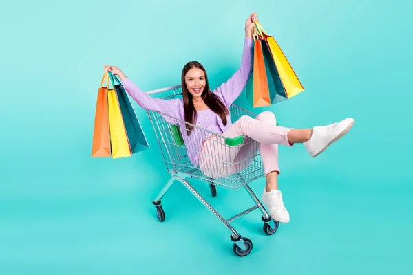 재미있는 젊은 여자가 웃으며 보라색 옷을 입고 쇼핑 트레이를 들고 있는 사진. — 스톡 사진