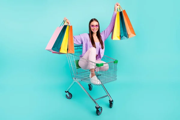 Foto de turismo señora paseo carro celebrar supermercado bolsas usar gafas de sol cárdigan púrpura aislado color verde azulado fondo —  Fotos de Stock