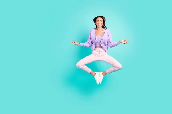 평온 한 여인 이 점프하는 사진 명상을 하는 모습 자주색 카디건 바지를 입고 있다. — 스톡 사진