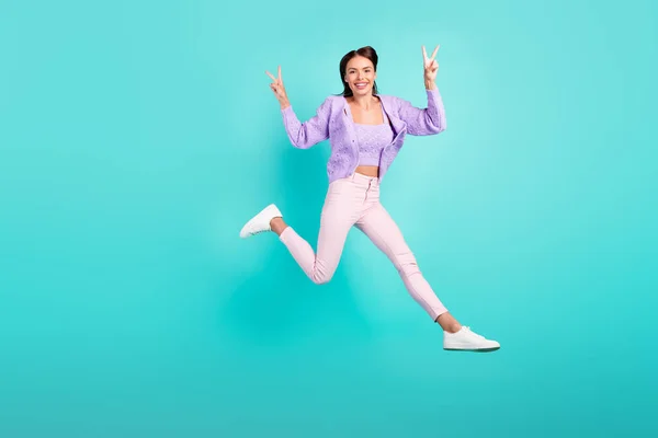 Foto de la señora joven brillante divertida usar traje violeta sonriendo saltando alto mostrando signos de v aislado color turquesa fondo —  Fotos de Stock