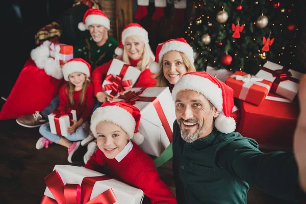Foto retrato de grande família cheia vestindo chapéu vermelho sorrindo juntos xmas espírito mantendo presentes pai tomando selfie — Fotografia de Stock