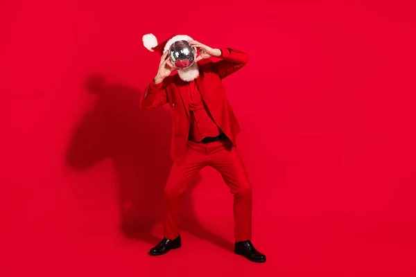 Foto von funky lustig Alter Gentleman tragen neue Jahr Kostüm Kopfbedeckung tanzen Discokugel schließen Gesicht isoliert rote Farbe Hintergrund — Stockfoto