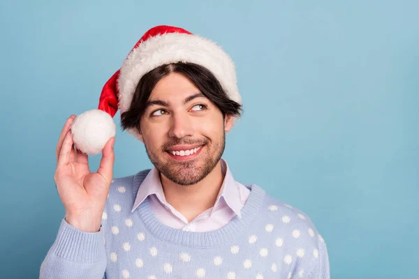 Foto von jungen verträumten glücklichen positiven Mann suchen leeren Raum tragen Weihnachtsmann Hut isoliert auf blauem Hintergrund — Stockfoto