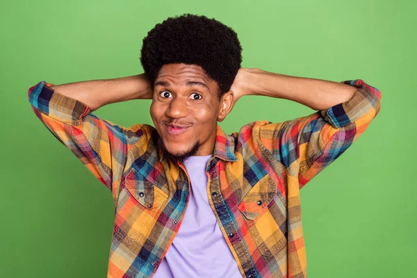 Foto de cara pele muito escura animado vestido braços quadriculados atrás da cabeça sorrindo isolado fundo cor verde — Fotografia de Stock