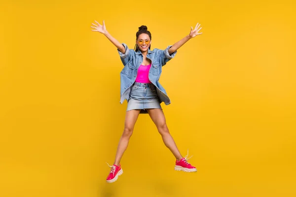 Foto de tamaño completo de la joven excitada chica negra feliz sonrisa positiva divertirse volar salto aislado sobre fondo de color amarillo — Foto de Stock