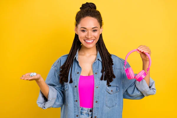 Photo de jeune fille noire heureux sourire positif tenir casque choix annonce isolé sur fond de couleur jaune — Photo