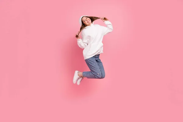 Full body profil fotografie mladé dámy skok nosit mikiny džíny tenisky izolované na růžovém pozadí — Stock fotografie