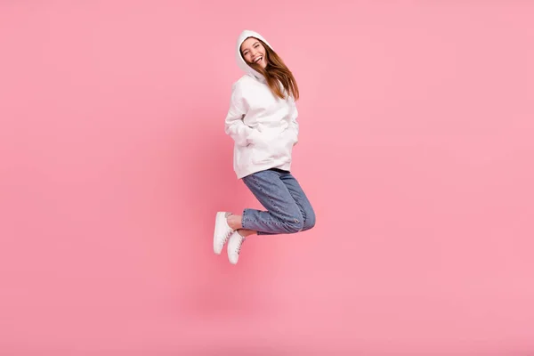 Full length profile photo of millennial lady jump wear hoodie jeans sneakers isolated on pink background — Stock Photo, Image