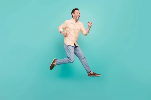 Foto lateral de perfil de tamaño completo del hombre sonriente corriendo velocidad rápida en el aire viajando turista aislado en color verde azulado fondo —  Fotos de Stock