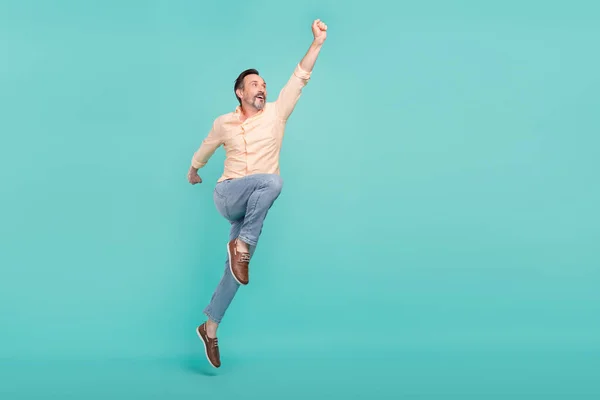 Foto em tamanho completo de idade engraçada homem salto desgaste camisa jeans tênis isolado no fundo cor teal — Fotografia de Stock