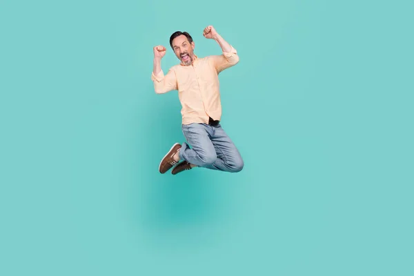 Foto de comprimento total de homem maduro funky salto desgaste camisa jeans tênis isolado no fundo cor teal — Fotografia de Stock