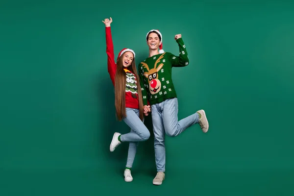 Foto von fröhlich erstaunt Paar freuen Sieg heben Fäuste tragen hässlichen Pullover isoliert grüne Farbe Hintergrund — Stockfoto